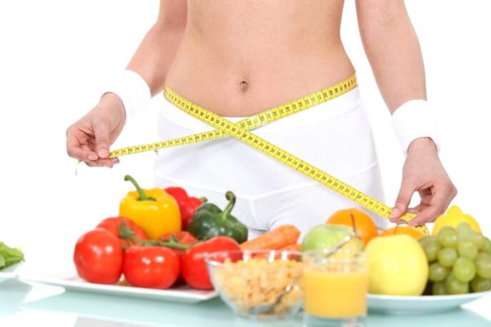 Girl measures waist against background of grocery store